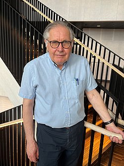 Portrait of Professor Hugo Lagercrantz standing by a staircase.