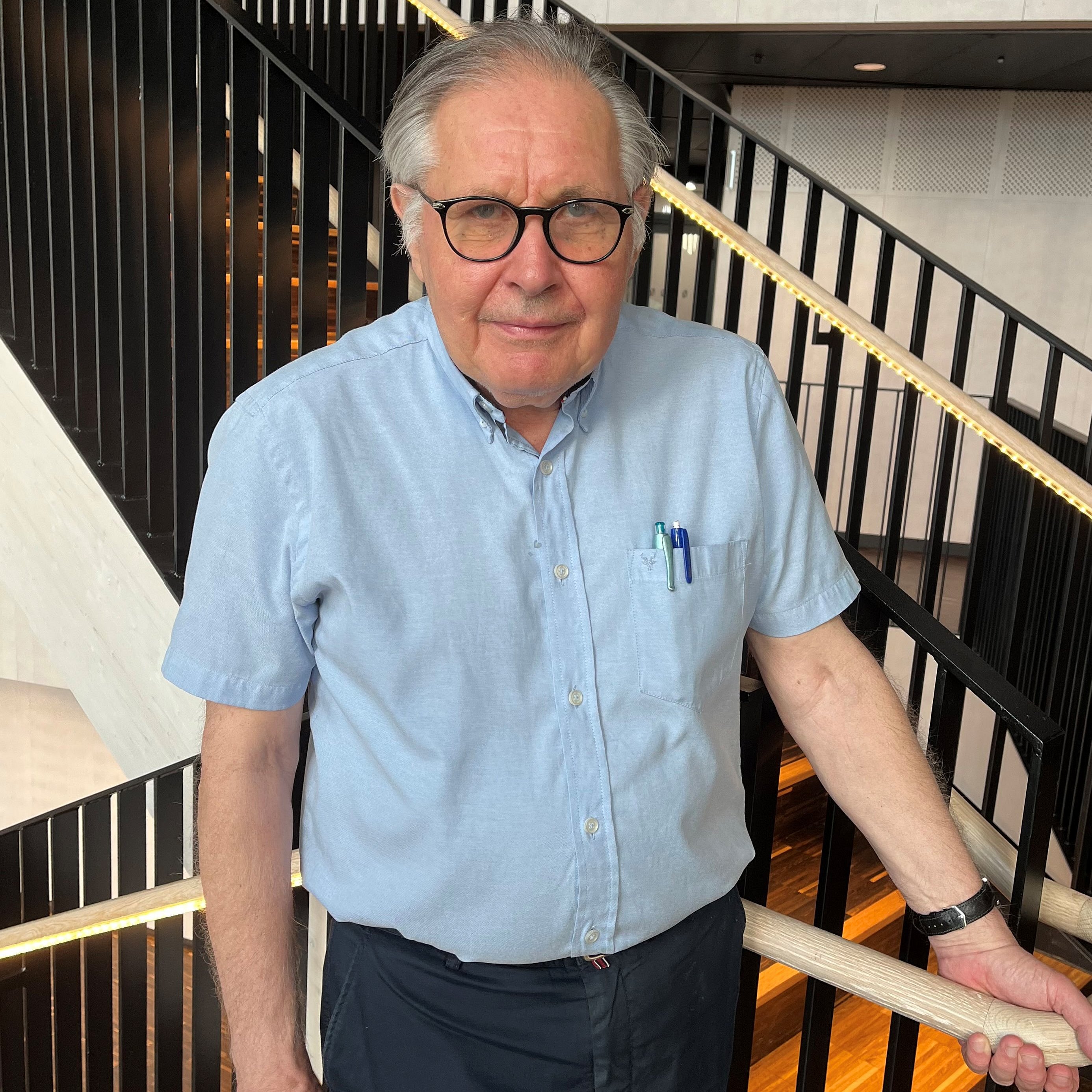 Portrait of Professor Hugo Lagercrantz standing by a staircase.