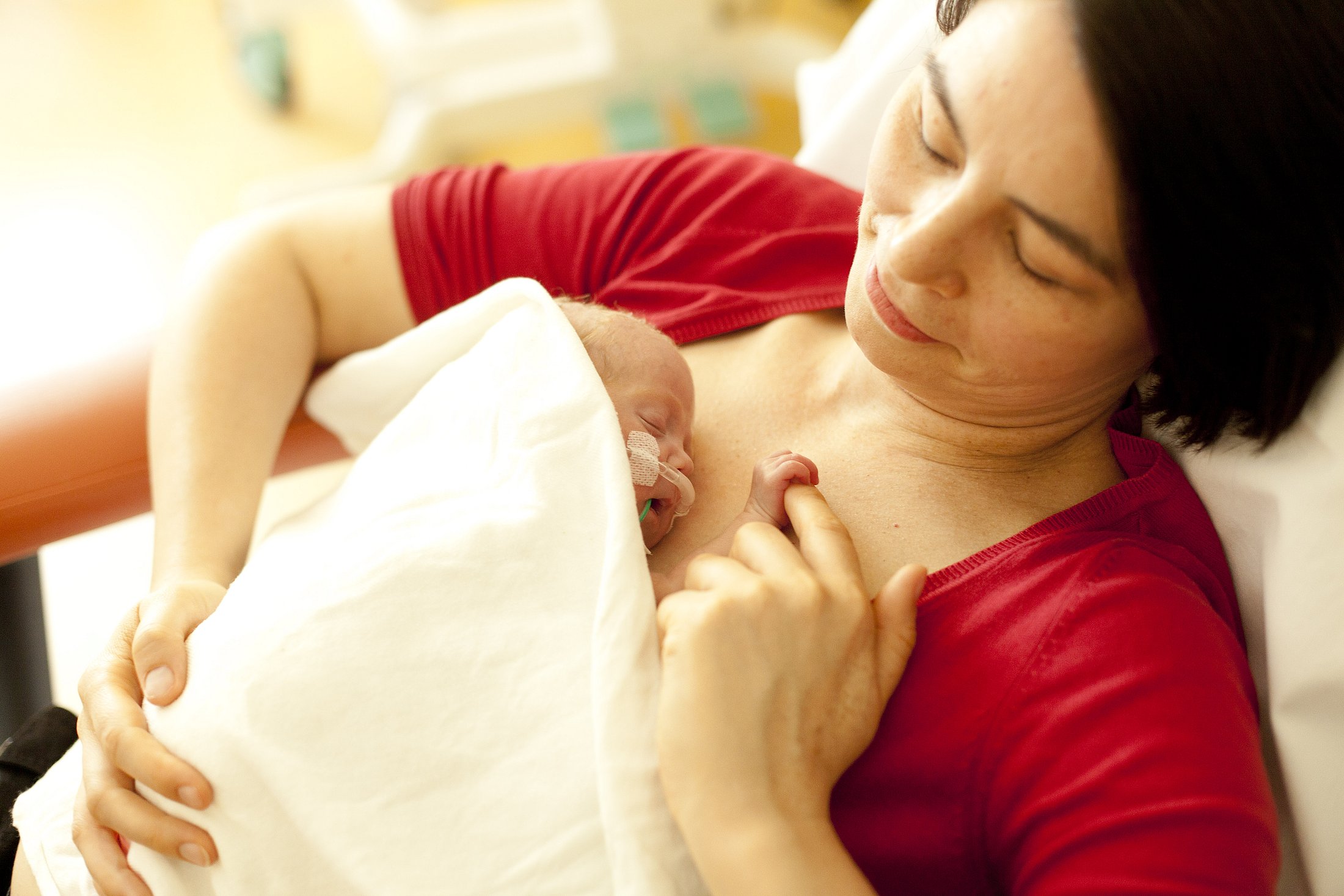 Mother Providing Skin-to-Skin Care to a Preterm Infant Mother holding a preterm infant against her chest during skin-to-skin care in the hospital.