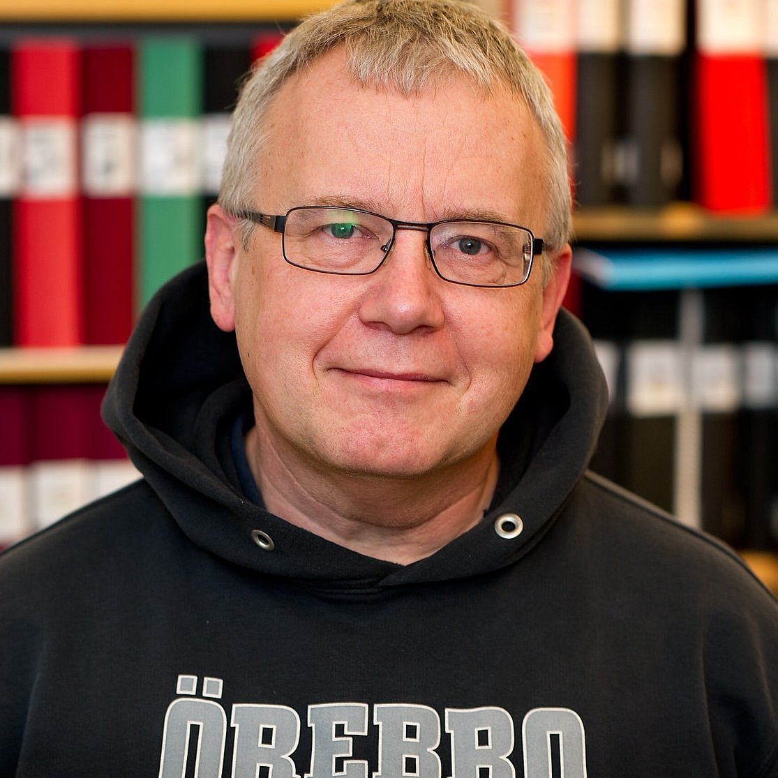 Portrait of Professor Mats Eriksson with bookshelves in the background.