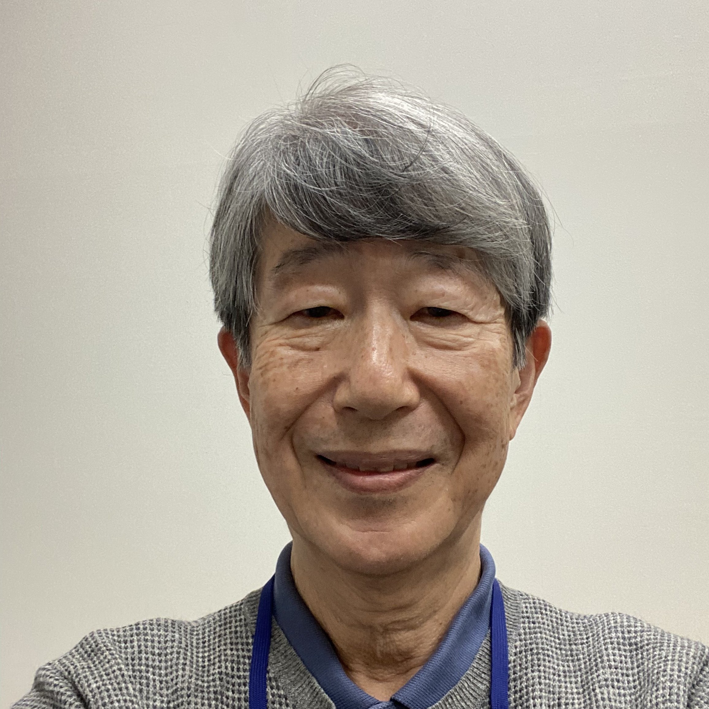 Portrait of Professor Satoshi Kusuda smiling in front of a neutral background. 