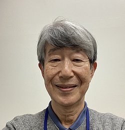 Portrait of Professor Satoshi Kusuda smiling in front of a neutral background. 