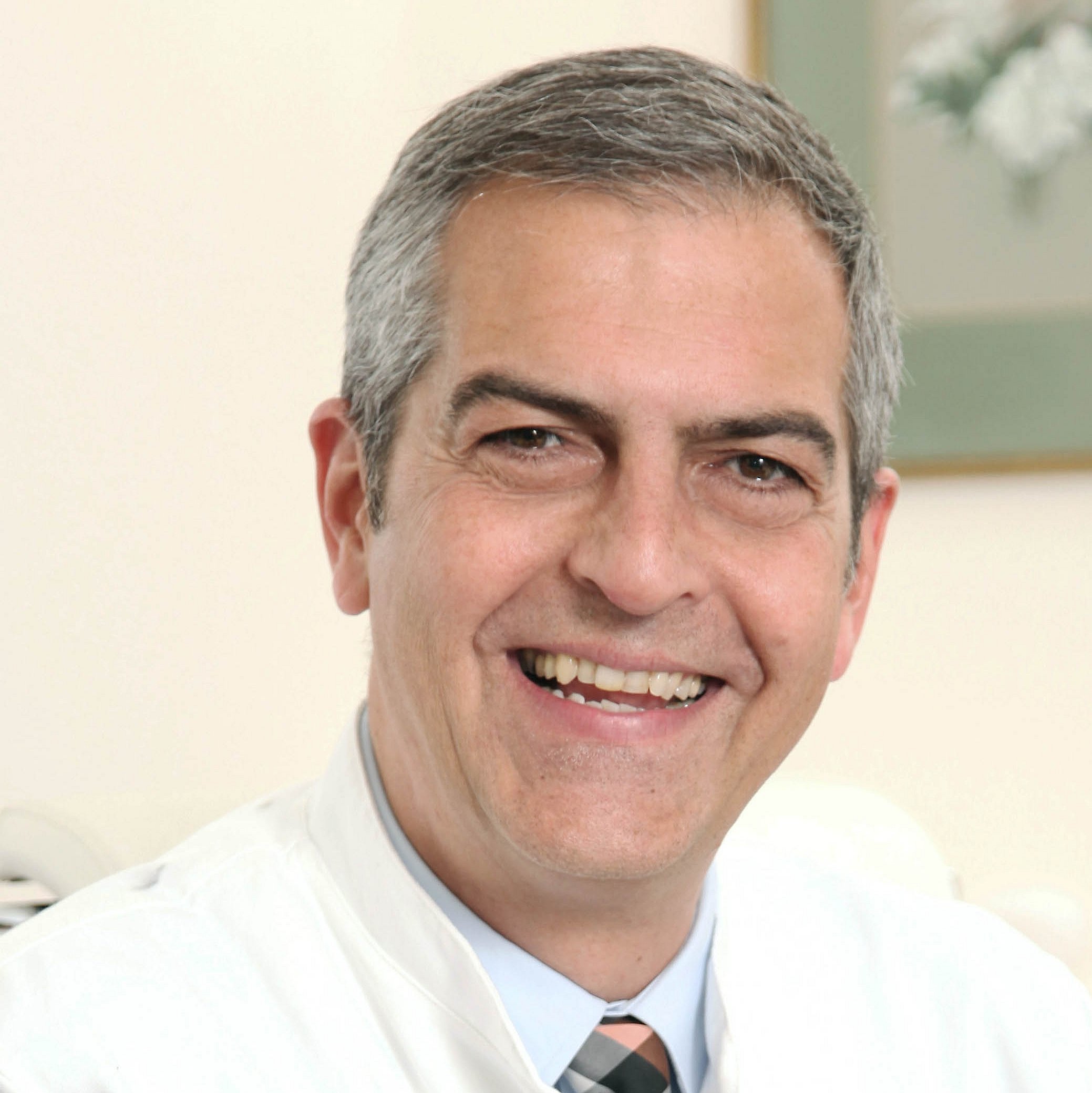 Portrait of Michael Abou-Dakn smiling in a white coat.