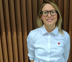 Portrait of Dr. Christina Tischer outdoors with a brick background.