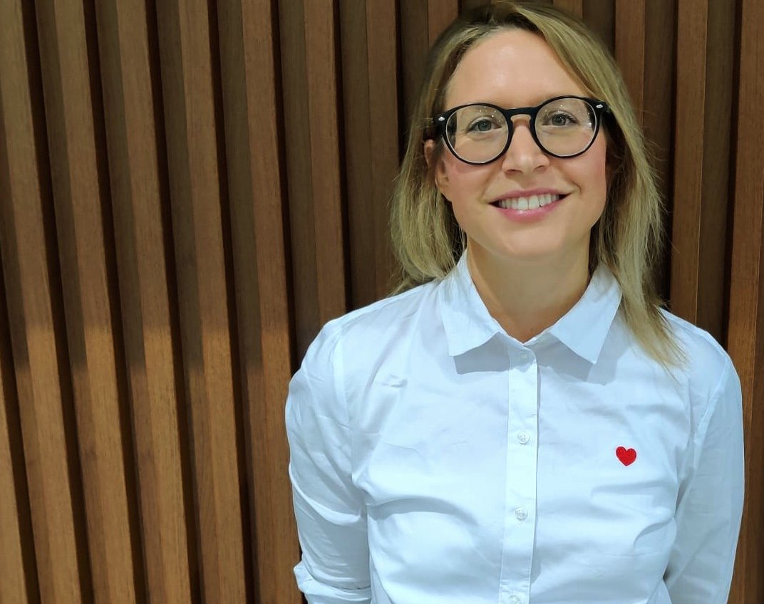 Portrait of Dr. Christina Tischer outdoors with a brick background.