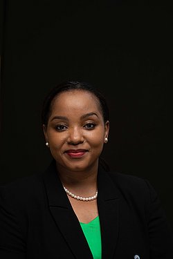Portrait Portrait of Doris Mollel in a black blazer with a green shirt.