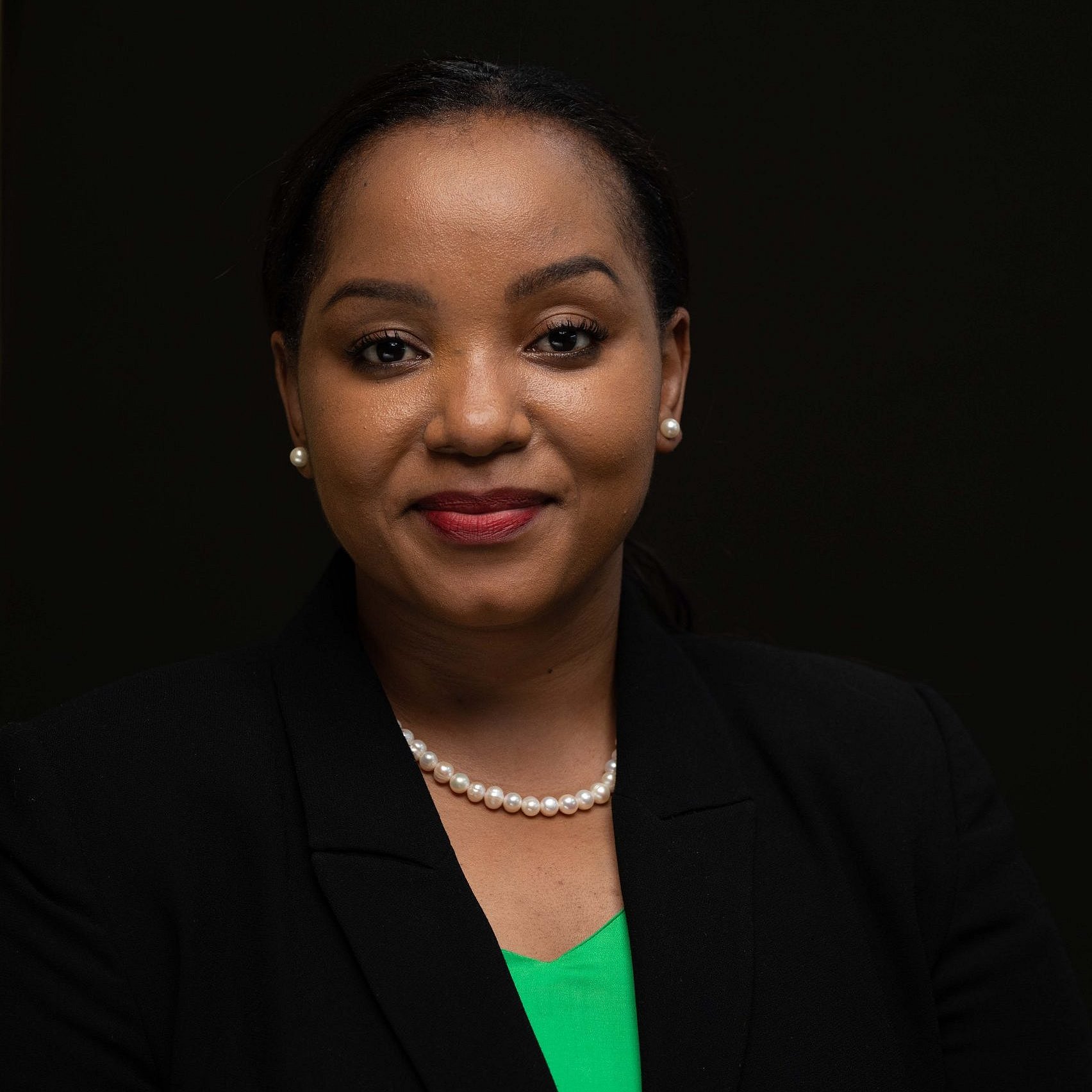 Portrait of Doris Mollel in a black blazer with a green shirt.