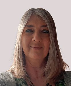 Portrait of Dr. Julia Petty smiling in front of a neutral background.
