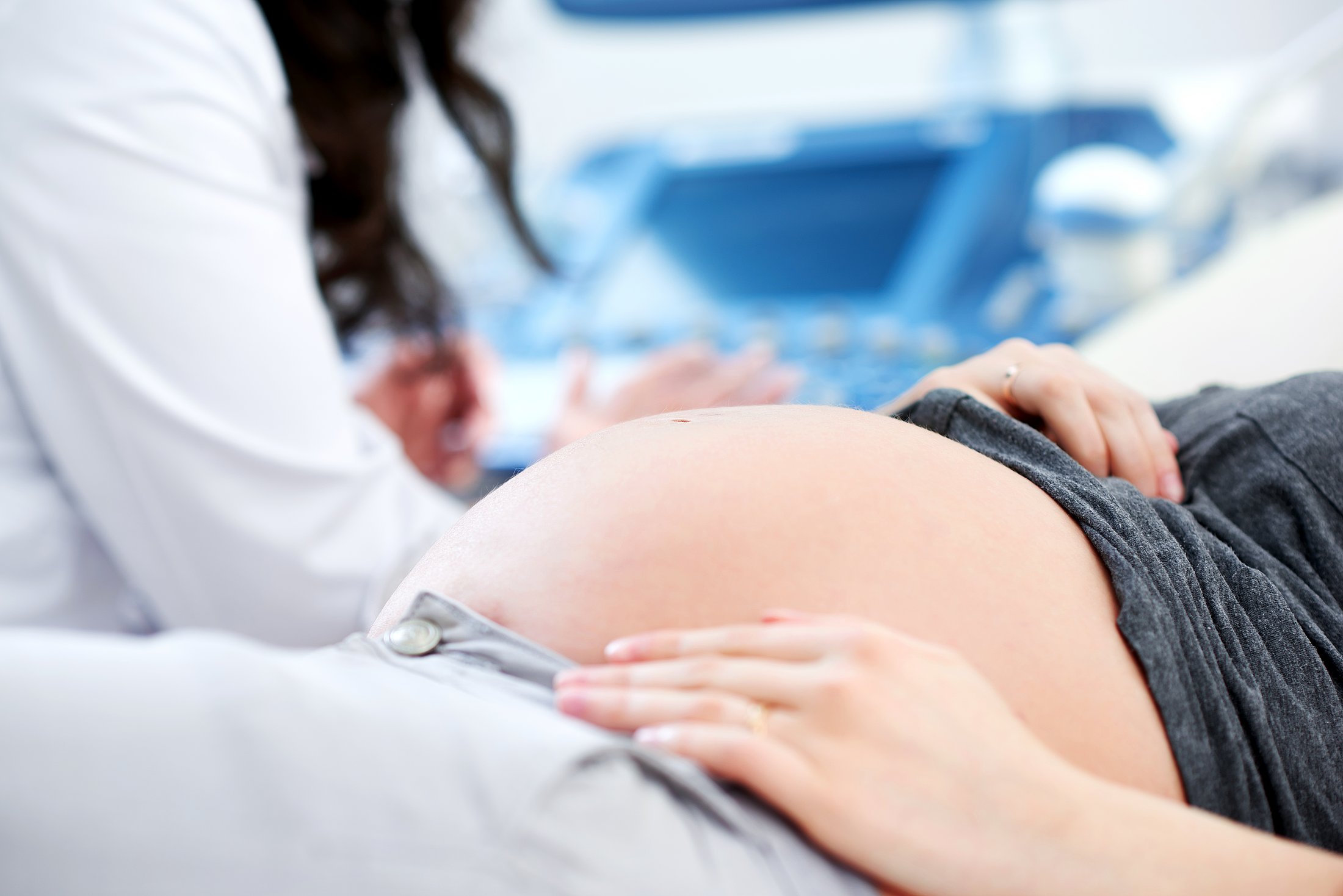 Prenatal Care and Pregnancy Complications Health care provider performing an ultrasound scan on a pregnant patient, representing prenatal care related to pregnancy complications and social needs.