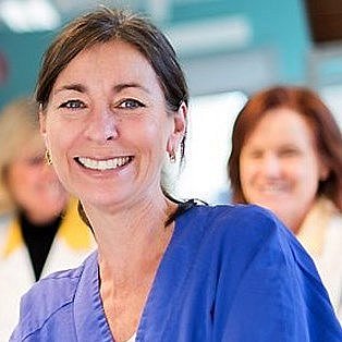Portrait of Ann Hellström smiling in a clinical setting.