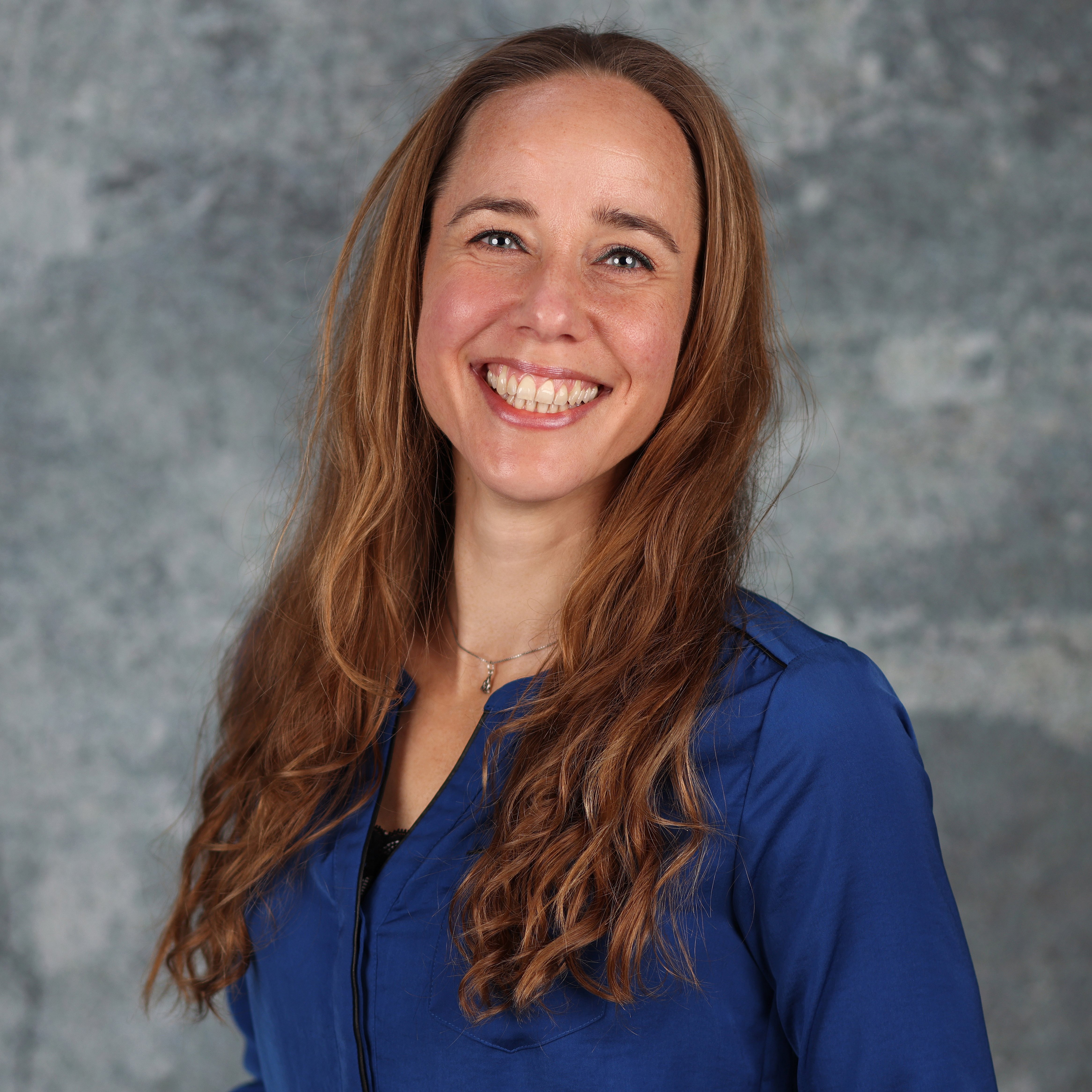 Professional Portrait of Juliëtte Kamphuis smiling against a neutral background.