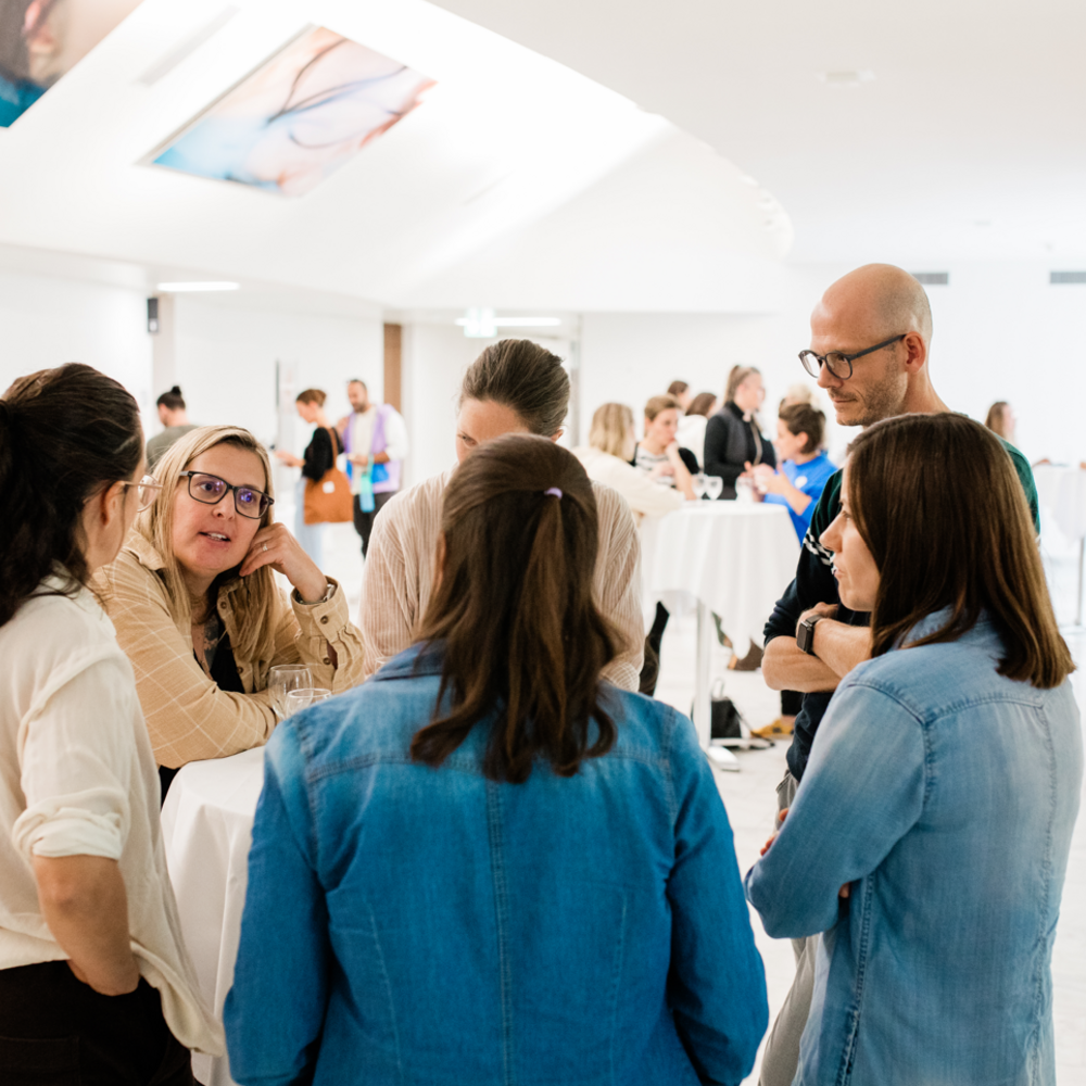 Participants gather in small groups for networking and discussion during the Peer Support Switzerland event.