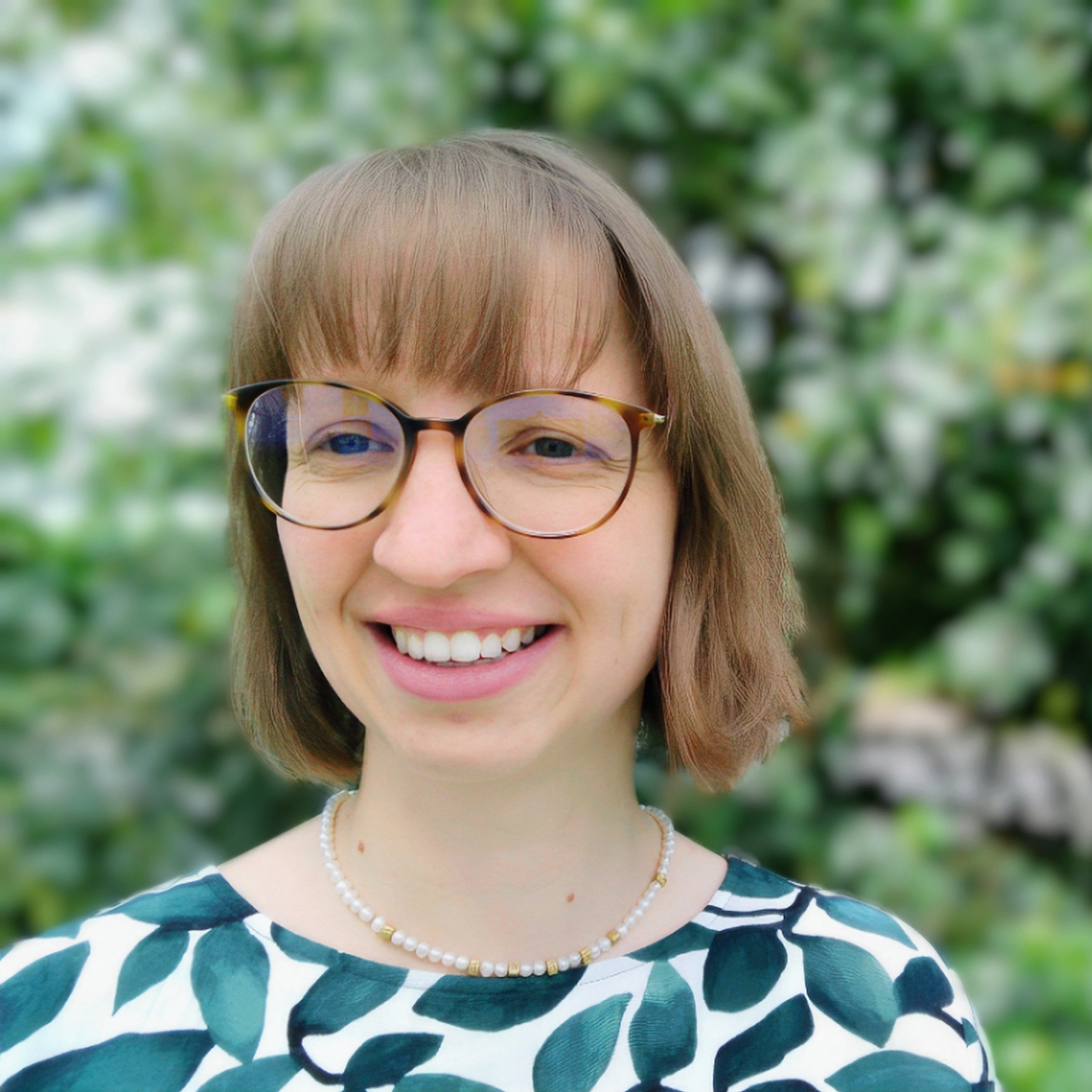 A professional headshot of Annika Brunck, smiling with a natural background.