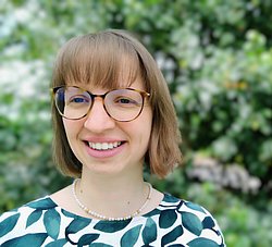 A professional headshot of Annika Brunck, smiling with a natural background.