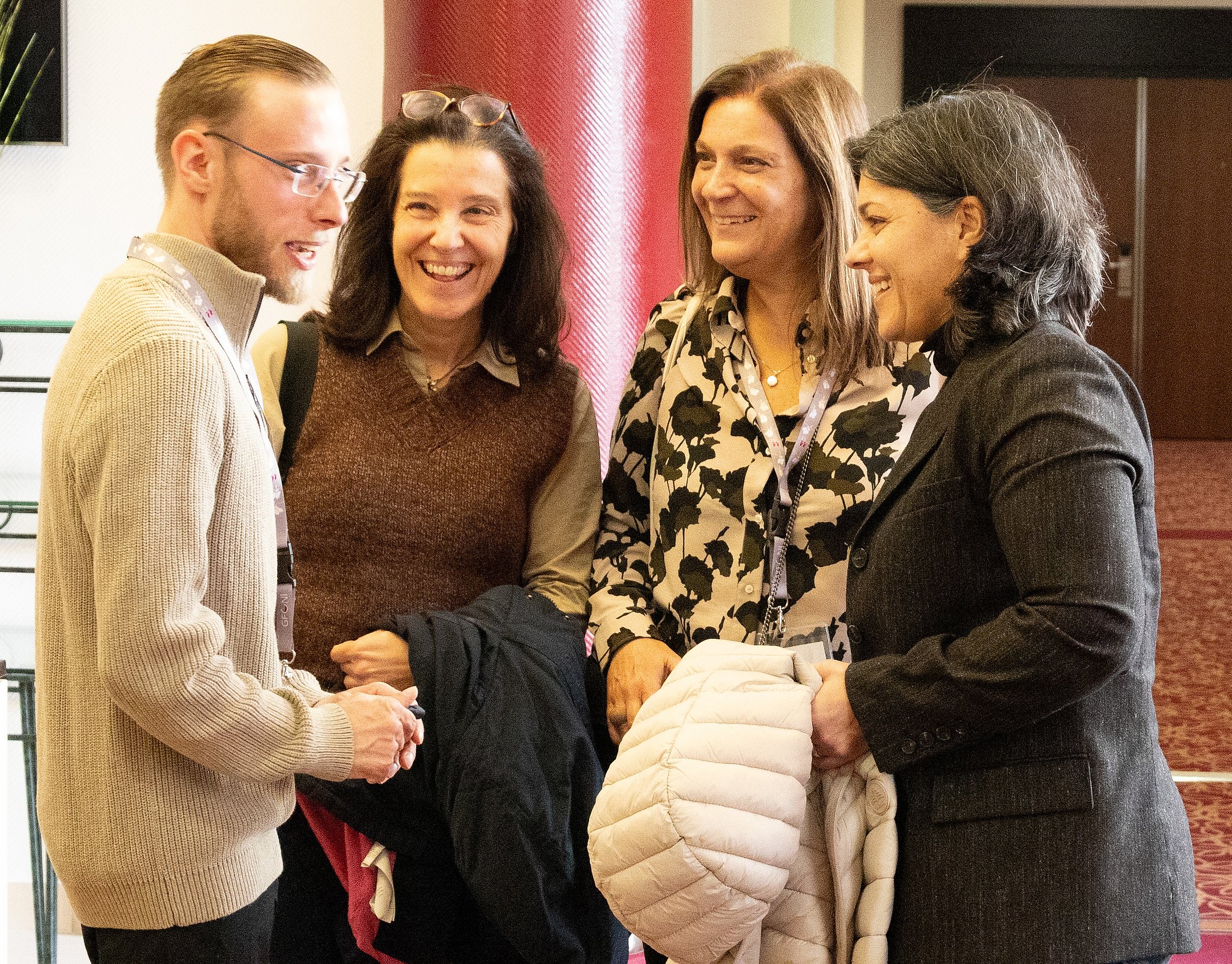 Four participants smiling and talking together during an international GFCNI networking event.