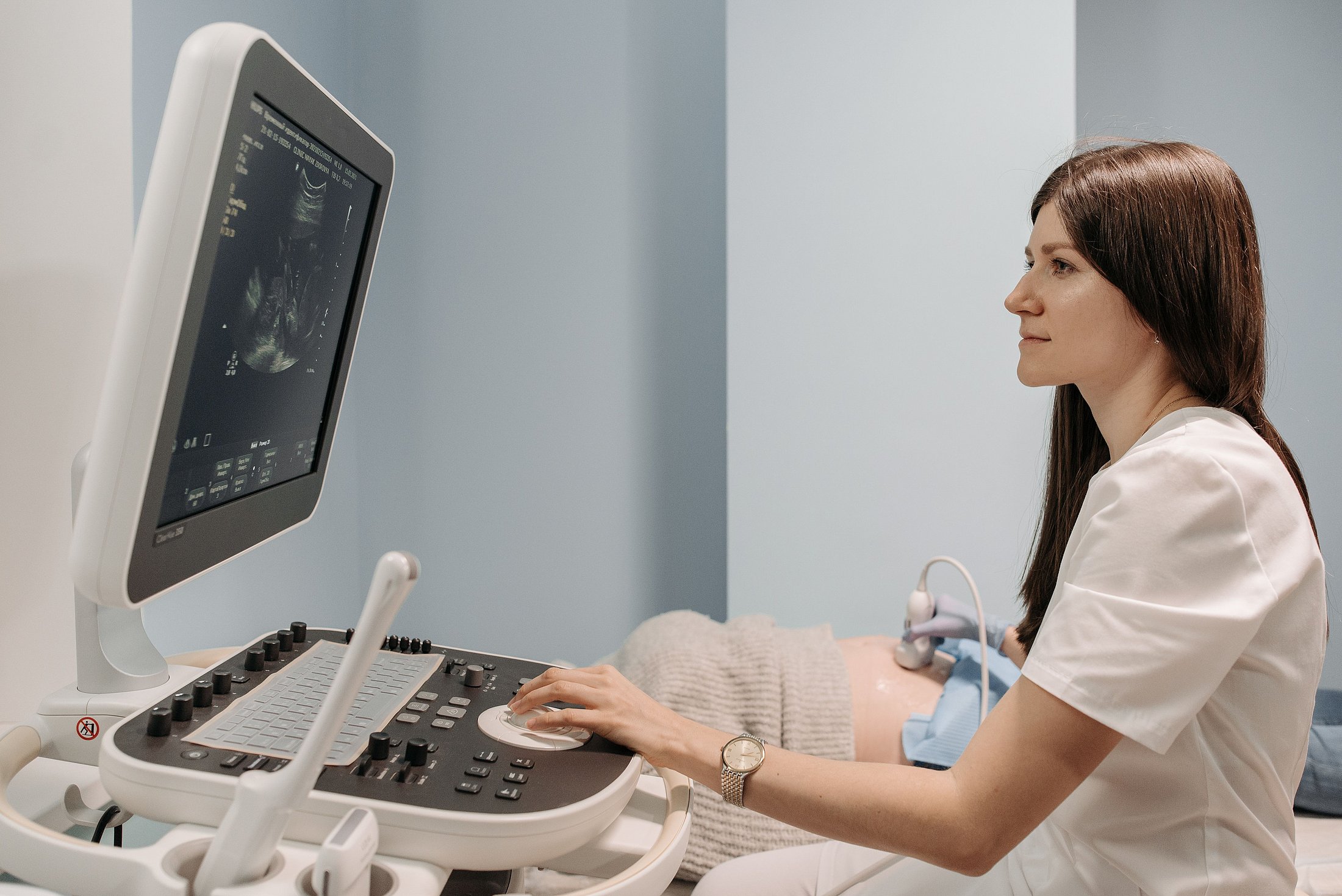 Ultrasound Monitoring During Pregnancy Healthcare professional operates an ultrasound machine while scanning a pregnant patient.