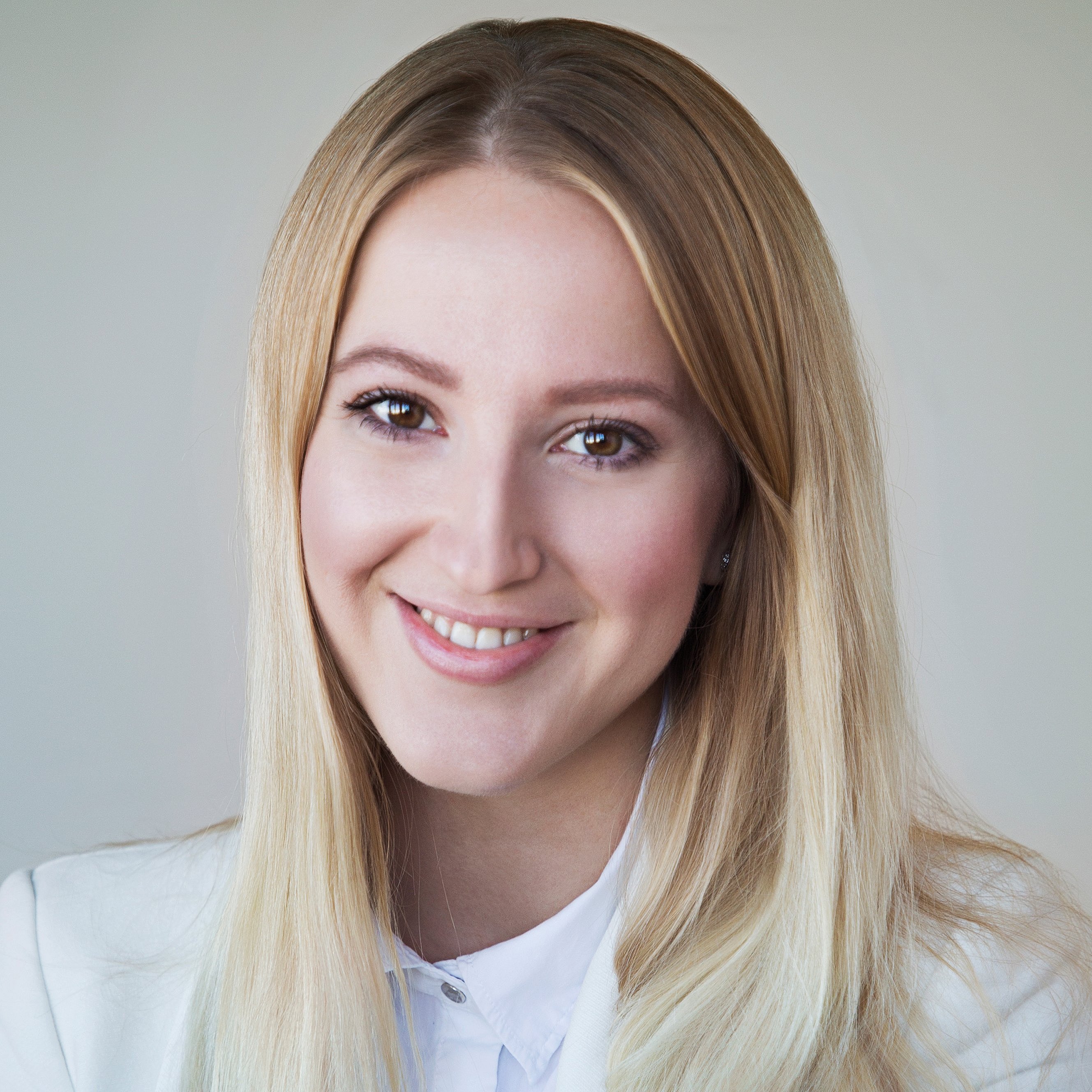A professional headshot of Diana Hofmann-Larina, smiling in a white blazer.