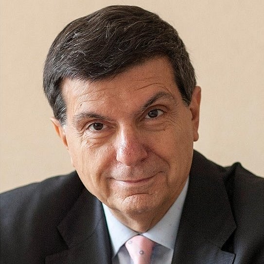 Portrait of Gian Carlo Di Renzo in a suit and tie.
