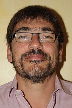 Portrait of Professor Pierre Kuhn with glasses and beard.