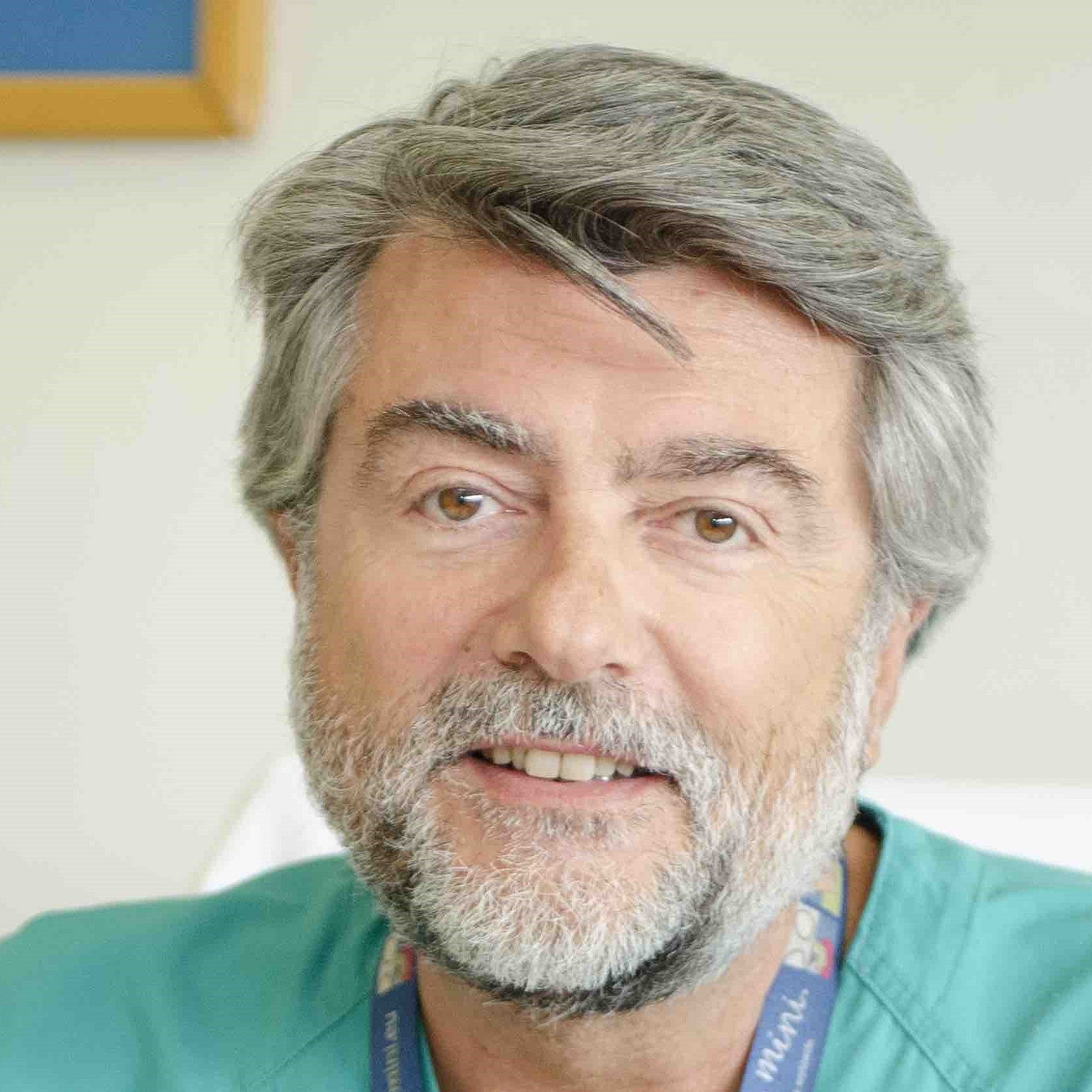 Portrait of Professor Manuel Sanchez Luna wearing a turquoise medical coat.