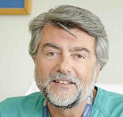 Portrait of Professor Manuel Sanchez Luna wearing a turquoise medical coat.