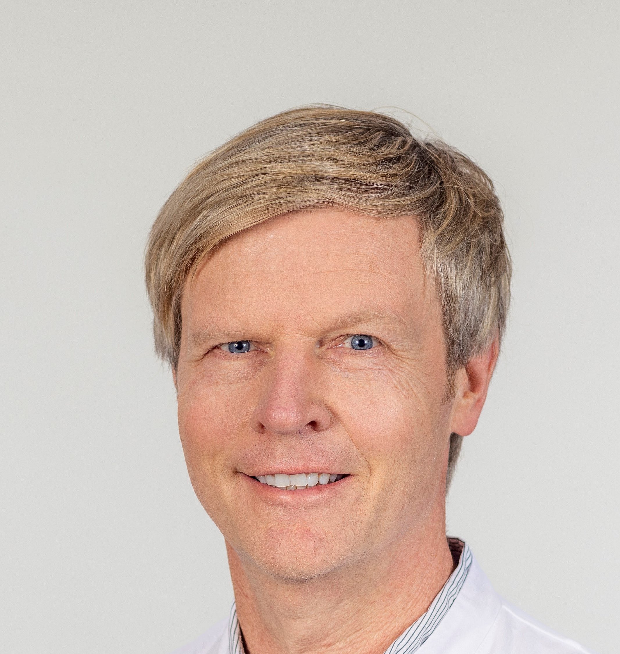 Portrait of Dr. Michael Poschmann in a white coat smiling