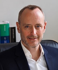 Portrait of Charles Roehr in an office setting.