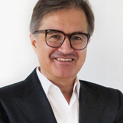 Portrait of Thomas Föringer wearing a suit and glasses