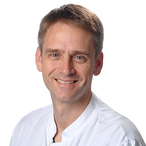 Portrait of Andreas Flemmer in a white coat.