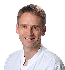 Portrait of Andreas Flemmer in a white coat.