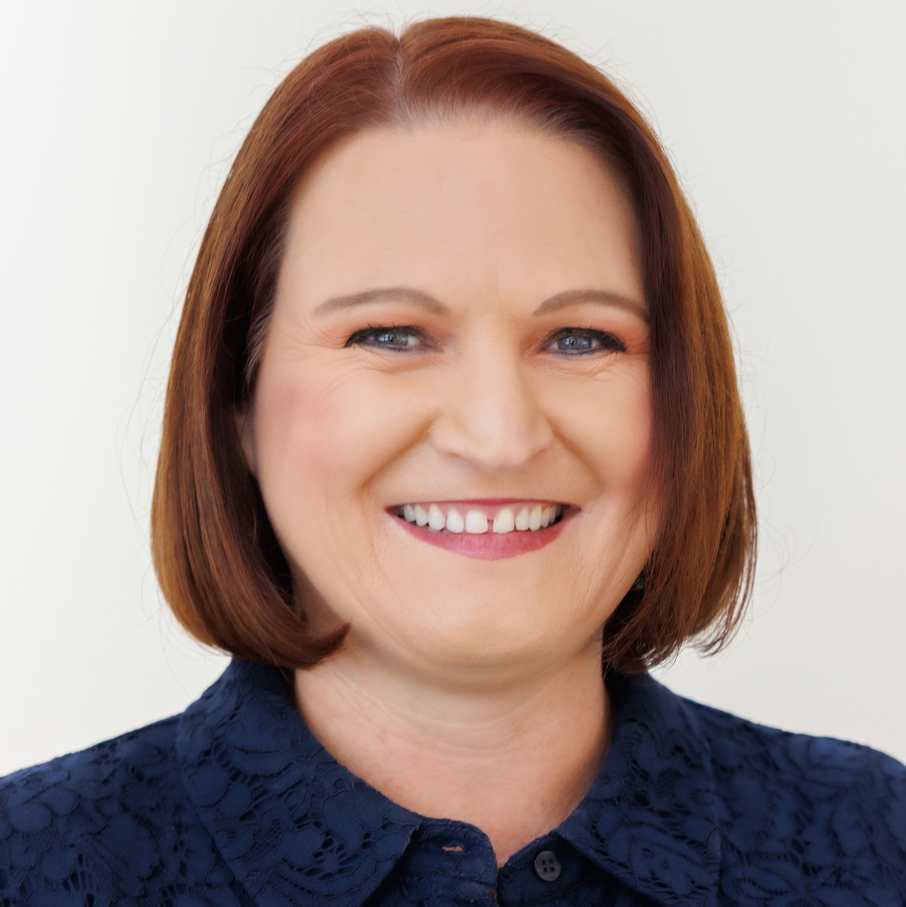 Professional headshot of Kylie Pussell, smiling in a dark blue shirt.