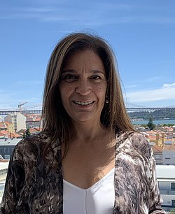 Paula Guerra Portrait Portrait of Paula Guerra smiling in front of a scenic cityscape.
