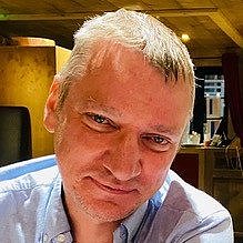 Portrait of Pierre Gressens in a casual shirt indoors.