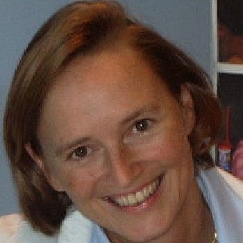 Portrait of Petra Hüppi smiling in a white coat.