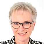 This is a portrait of Professor Agnes van den Hoogen, smiling and wearing glasses and a black-and-white patterned pullover.