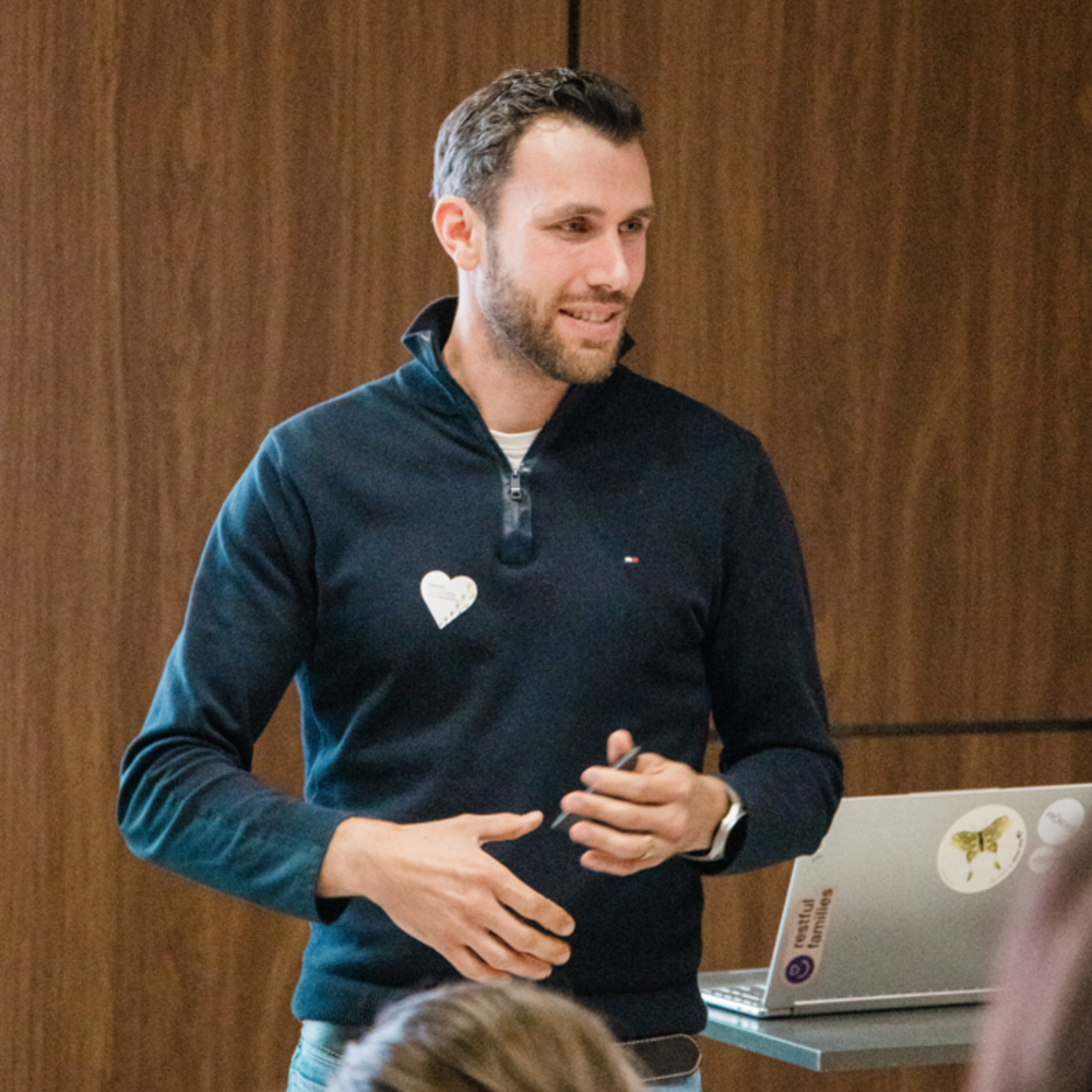 A father speaking at the Peer-Event standing in front of an audience.