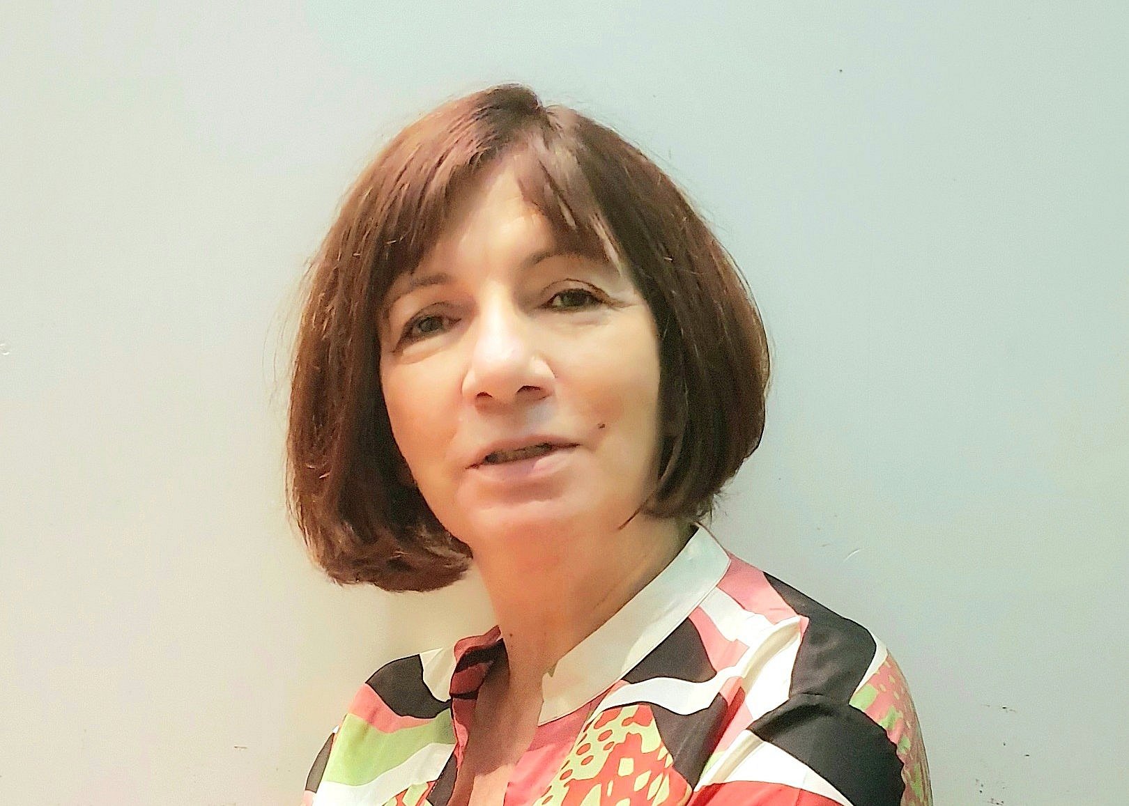 Eleni Vavouraki in a floral blouse with a composed and professional expression.