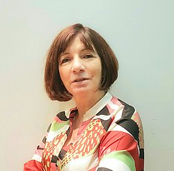 Eleni Vavouraki Eleni Vavouraki in a floral blouse with a composed and professional expression.