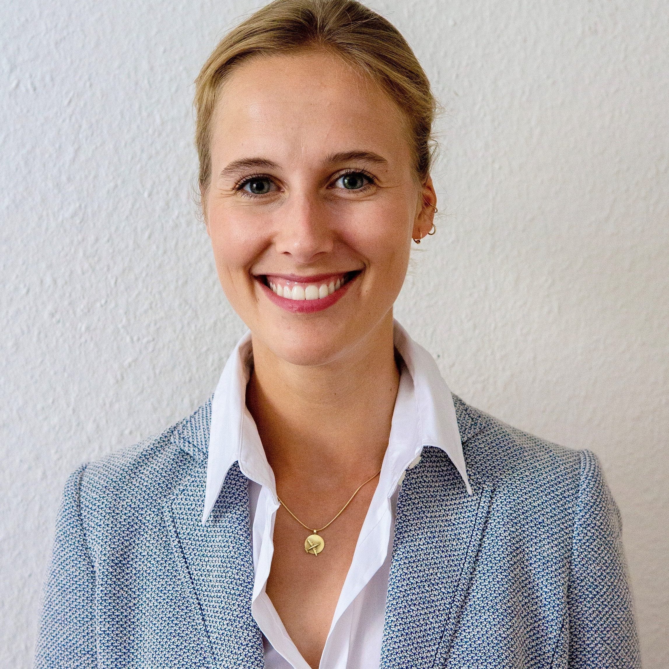 A professional portrait of headshot of Charlotte von Rosenstiel Pulver wearing a blue blazer.