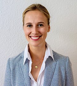 A professional portrait of headshot of Charlotte von Rosenstiel Pulver wearing a blue blazer.
