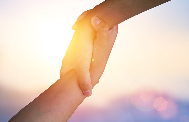 Two hands clasping in support, representing unity and collaboration in newborn care.