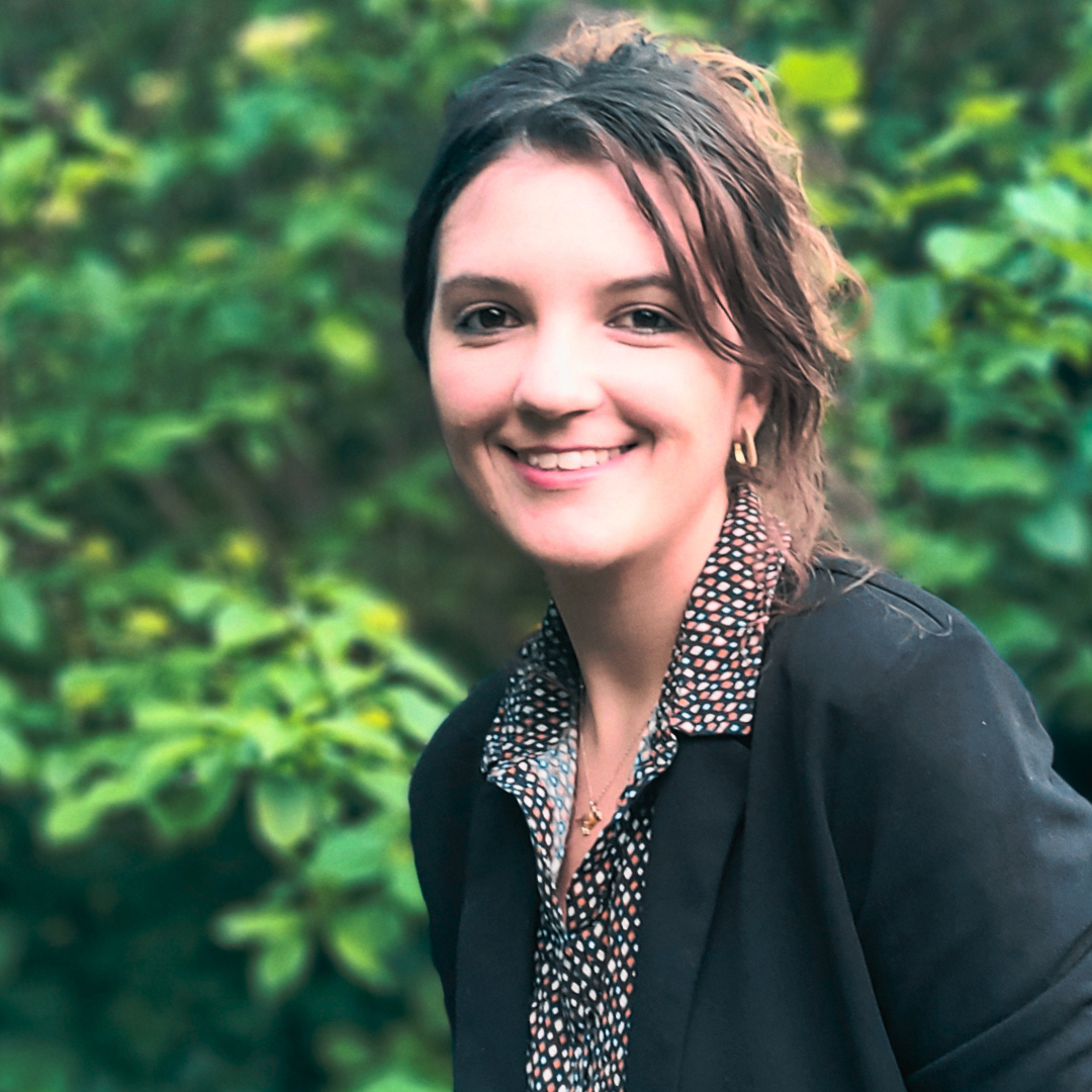 A professional headshot of Ramona Rangott with a garden background.