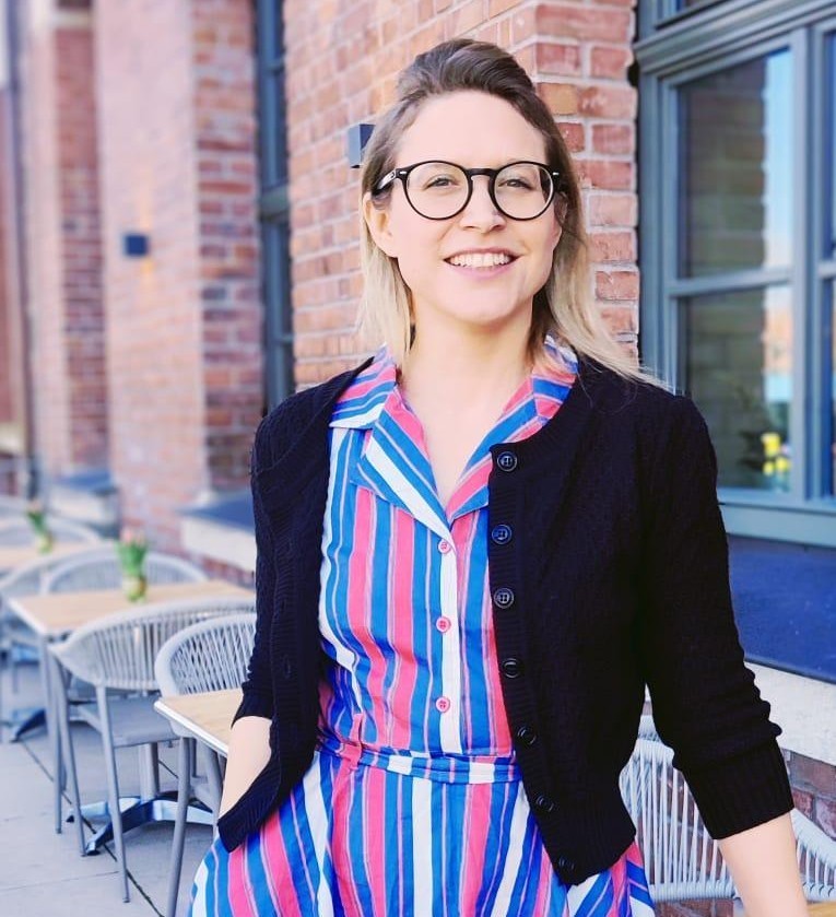 Portrait of Dr. Christina Tischer outdoors with a brick background.