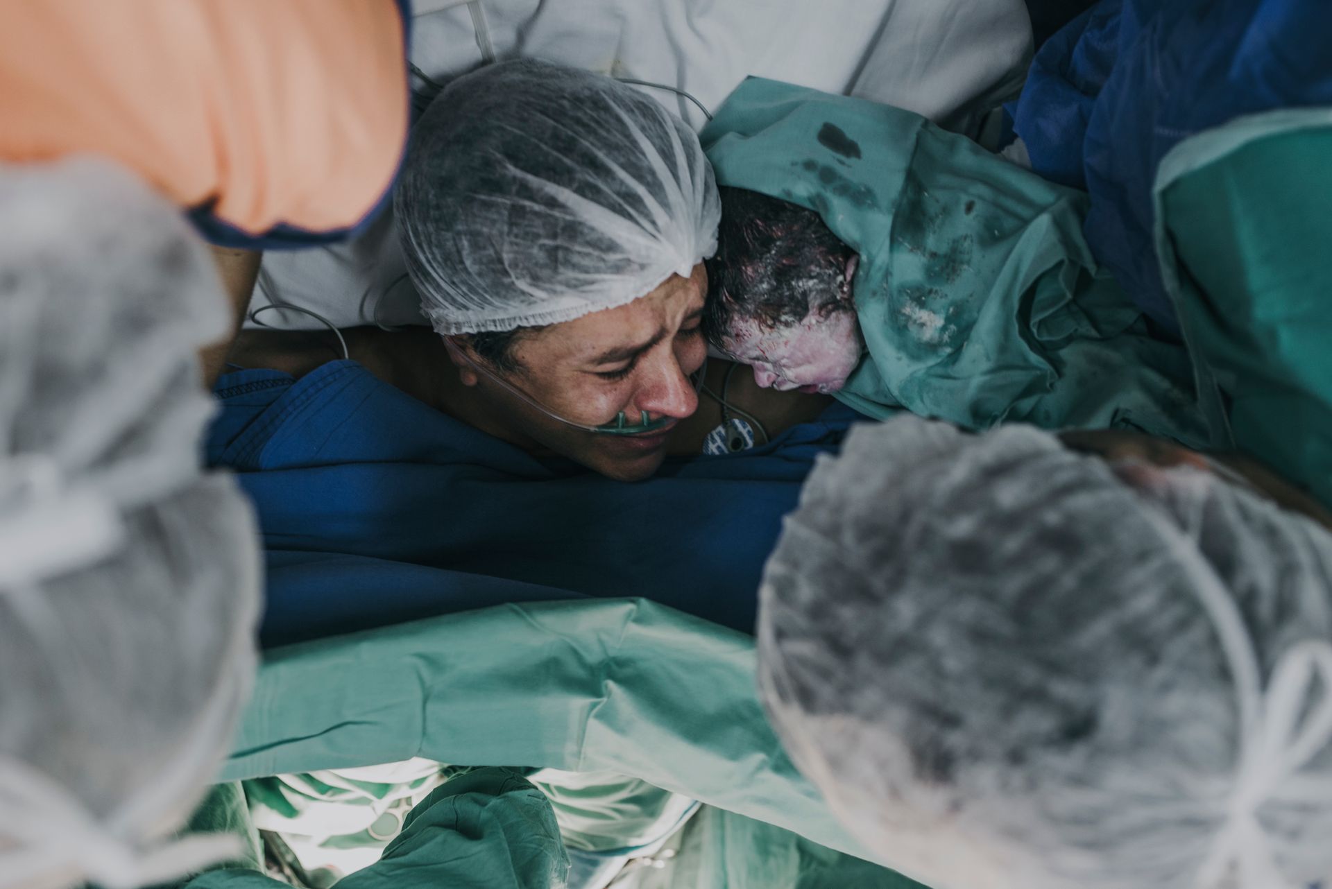 Mother meeting her newborn immediately after birth Mother touching her newborn immediately after delivery while healthcare professionals provide care.