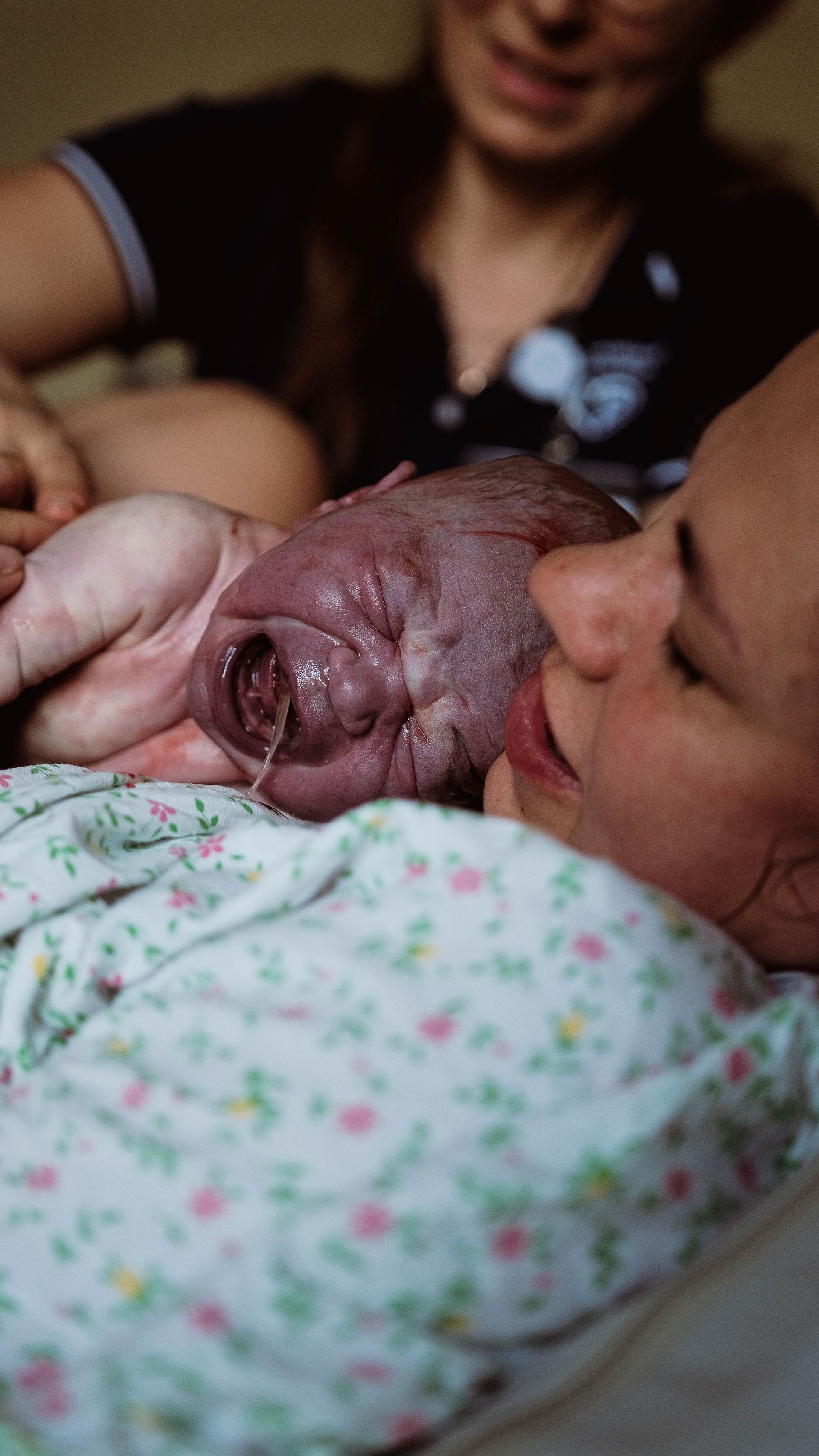 Mother and newborn after birth in a low-resource setting Mother holding her newborn immediately after birth in a modest healthcare setting.