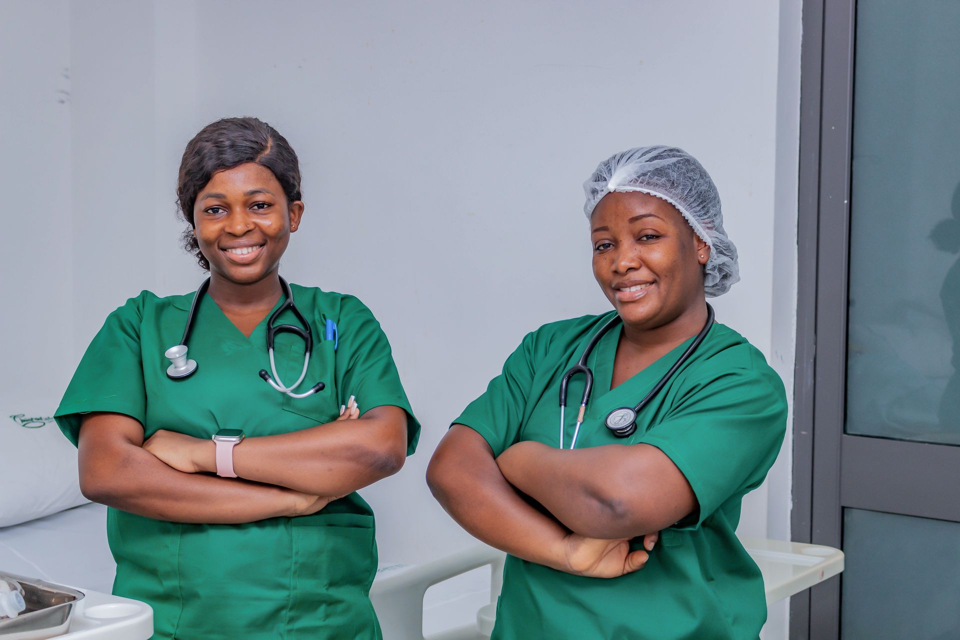 Midwives Supporting Maternal Health Worldwide Two maternal healthcare professionals in green clinical scrubs standing together.