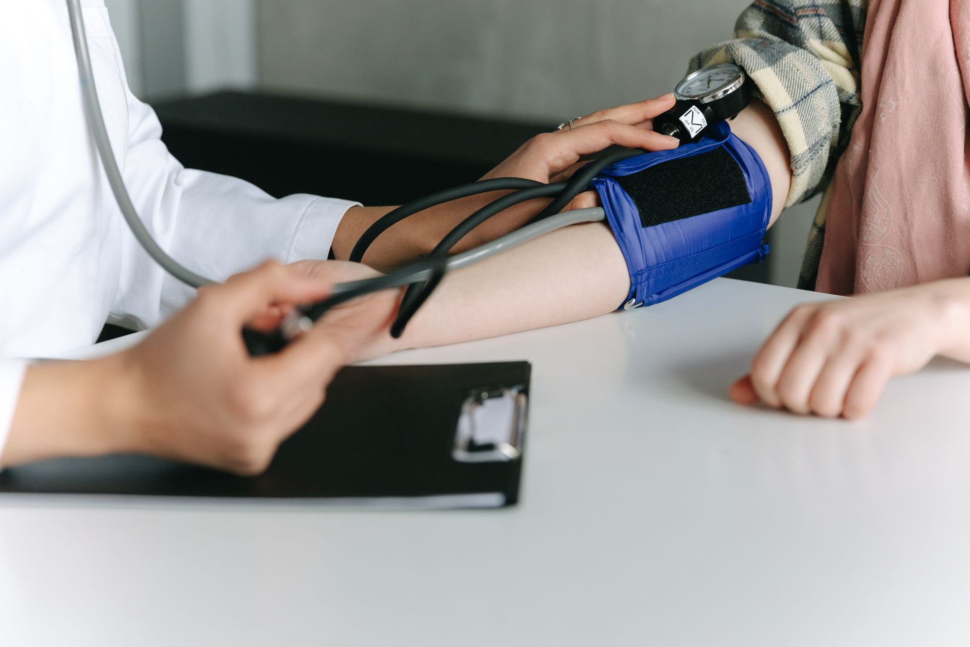 Healthcare professional measuring a patient’s blood pressure Healthcare professional measuring a patient’s blood pressure during a clinical appointment.