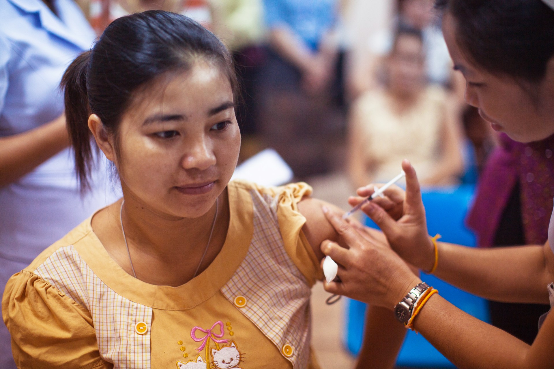 Vaccination as part of preconception care Woman receiving a vaccination from a healthcare worker as part of preventive care.