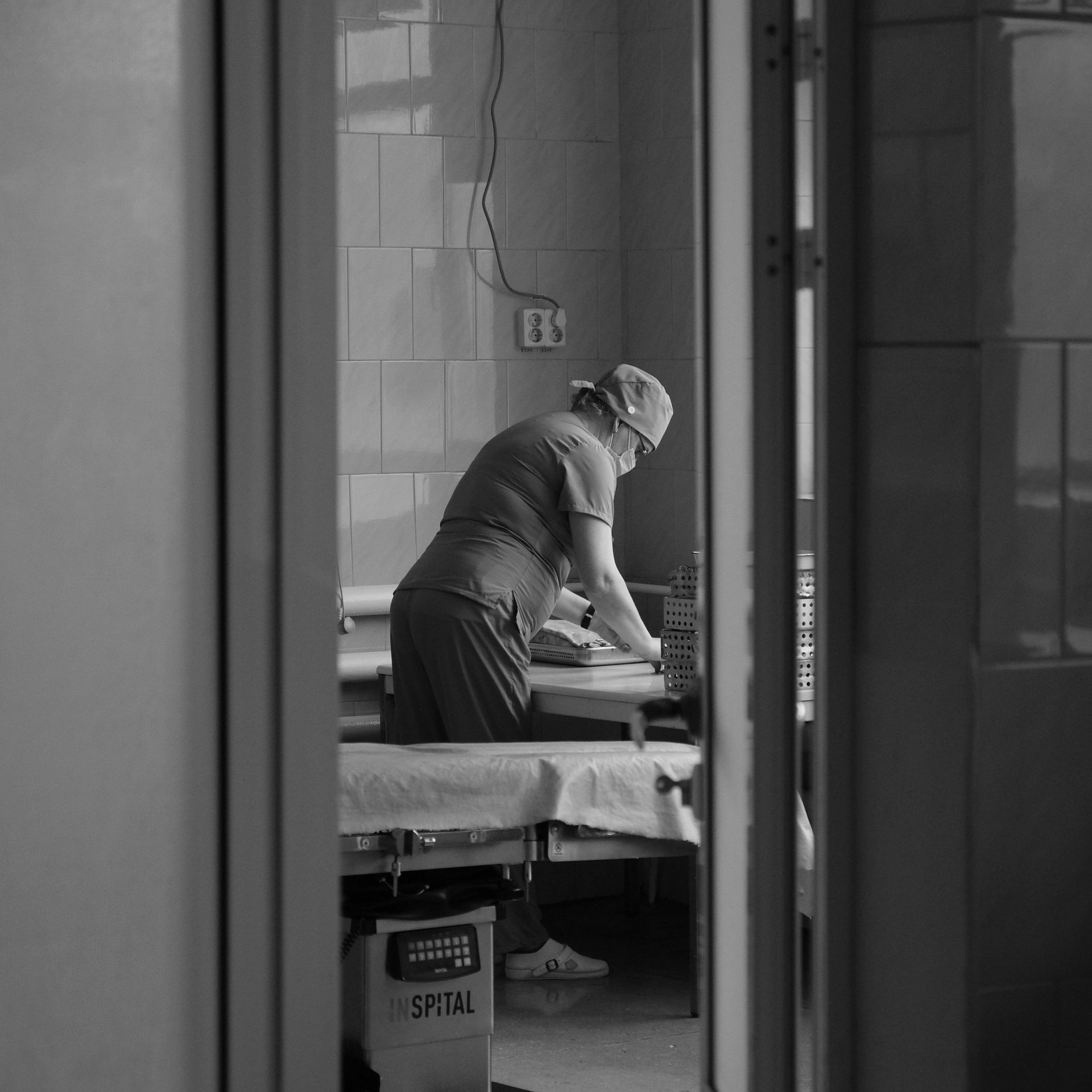 Healthcare worker preparing a clinical room in a low-resource setting Healthcare worker preparing equipment in a modest clinical room in a low-resource setting.