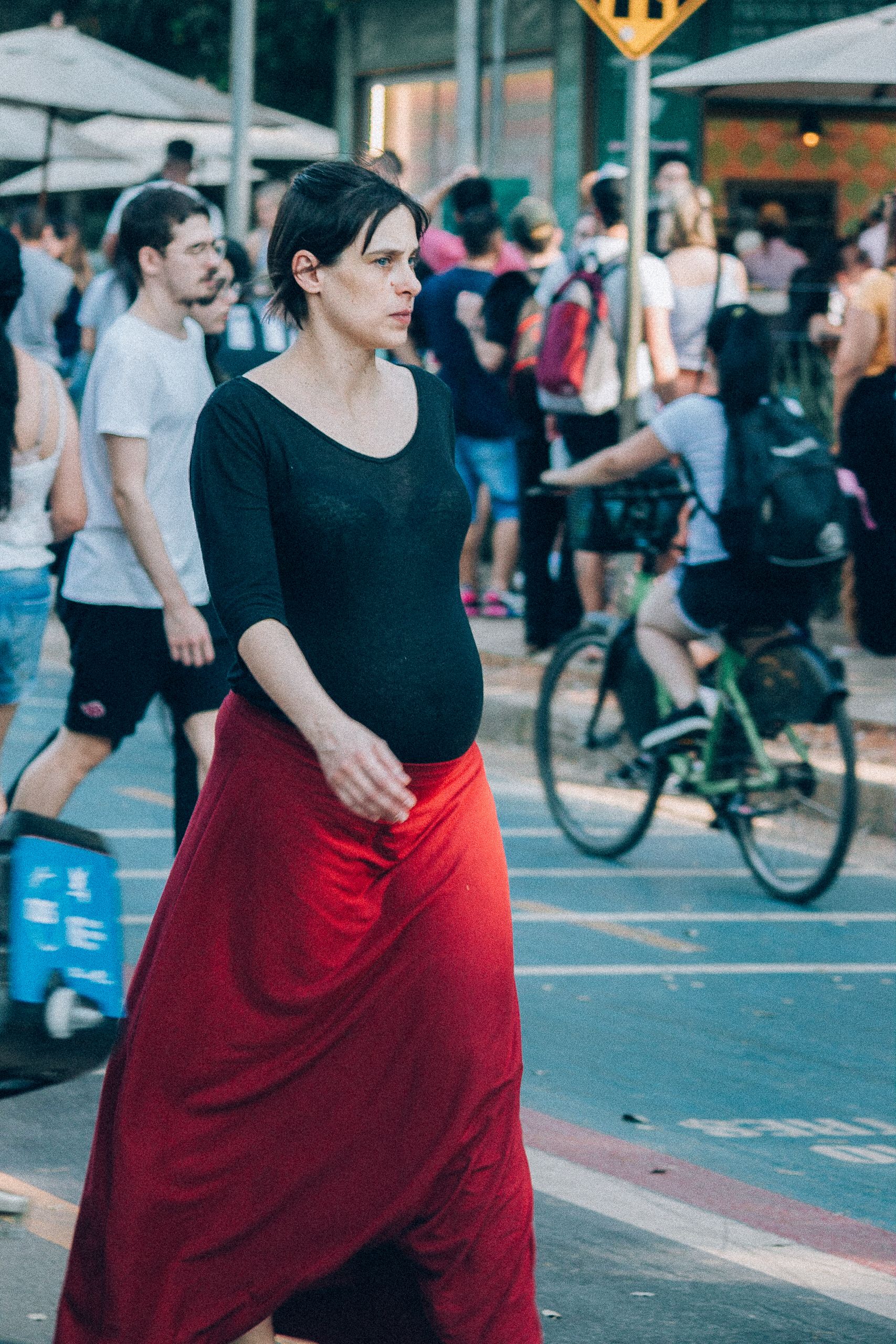 Pregnant woman walking outdoors during pregnancy Pregnant woman walking outdoors through a busy public area.